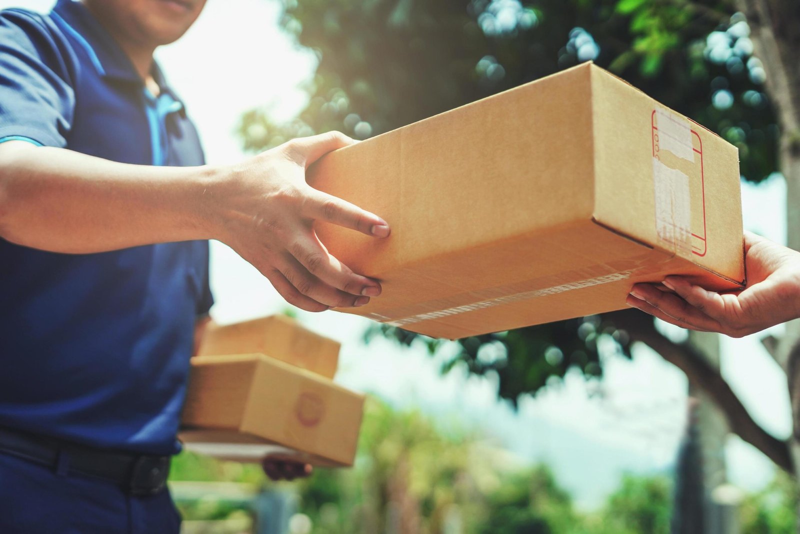 delivery-man-delivering-holding-parcel-box-to-customer-free-photo